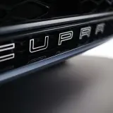 Napis CUPRA na czarnym grillu samochodu.