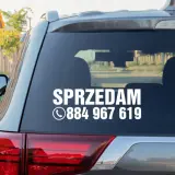 Nalepka na szybę samochodu z napisem "SPRZEDAM" i numerem telefonu.