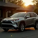 Srebrny samochód hybrydowy SUV zaparkowany przed domem o zachodzie słońca.