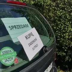 Tylna szyba samochodu z naklejkami "SPRZEDAM", "KUPIĘ ZADZWOŃ JUTRO!" i "STREFA KULTURALNEJ JAZDY".