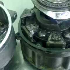 Rozłożone sprzęgło elektromagnetyczne klimatyzacji z widocznymi elementami mechanicznymi.