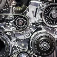 Zbliżenie na mechanizm silnika samochodowego z paskami i kołami pasowymi.