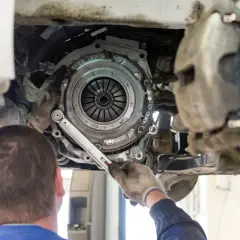 Mechanik wymieniający sprzęgło w samochodzie VW Passat.