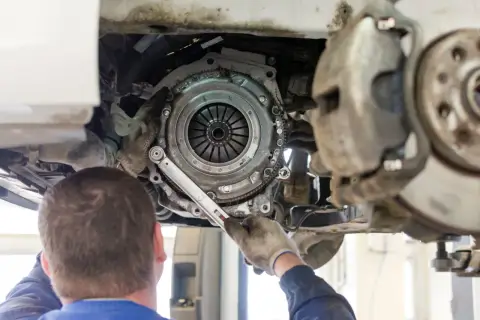 Mechanik wymieniający sprzęgło w samochodzie VW Passat.