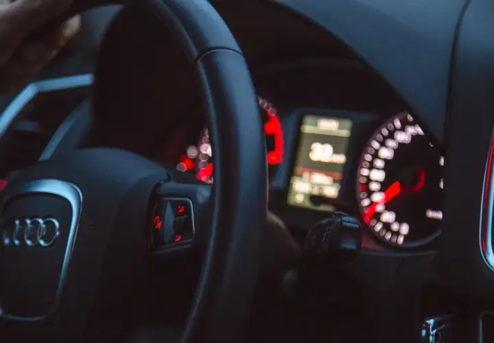 Widok na deskę rozdzielczą samochodu Audi z kierownicą i wskaźnikami.