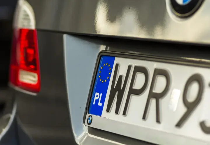 Zbliżenie na polską tablicę rejestracyjną samochodu z literami "WPR" i cyframi "93".
