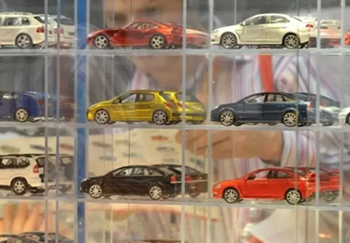Modeliki samochodów w gablotach: białe kombi, czerwony sportowy, żółty hatchback, granatowy sedan, srebrny coupe.