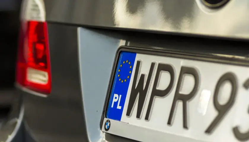 Zbliżenie na polską tablicę rejestracyjną samochodu z literami "WPR" i cyframi "93".