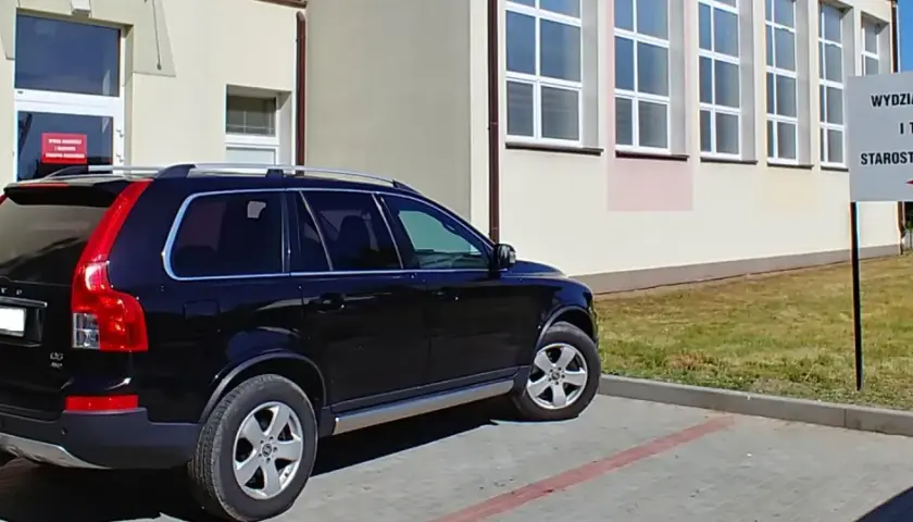 Czarny SUV zaparkowany przed budynkiem Wydziału Komunikacji i Transportu Starostwa Powiatowego.