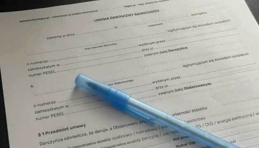 Niebieski długopis leży na dokumencie "Umowa darowizny samochodu".