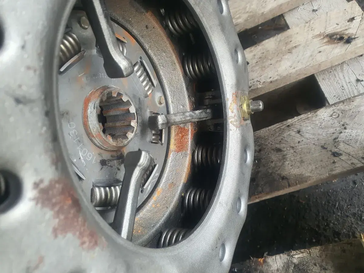 Zbliżenie na mechanizm docisku sprzęgła z widocznymi sprężynami i elementami regulacyjnymi.